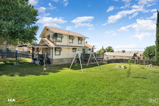 rear view of house featuring a yard and a playground