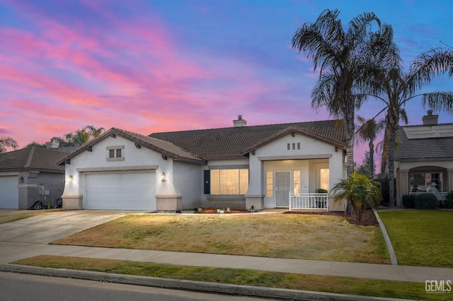 ranch-style house with a garage and a lawn