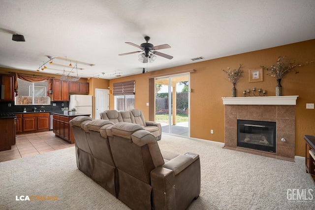 10815 Lewelling St, Bakersfield, CA 93312 - living room featuring ceiling fan, light colored carpet, rail lighting, and a fireplace
