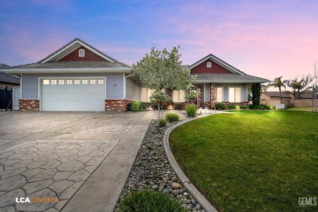 view of front of property featuring driveway, a garage, a lawn, and brick siding