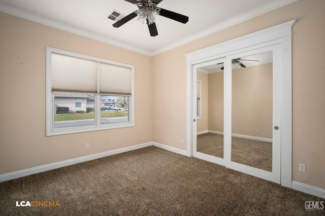 unfurnished bedroom with ceiling fan, baseboards, ornamental molding, carpet flooring, and visible vents