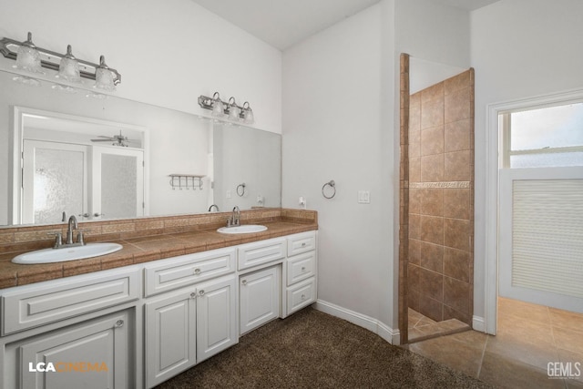 bathroom featuring double vanity, a sink, a walk in shower, and ceiling fan