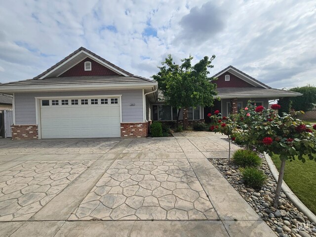 craftsman inspired home with concrete driveway, an attached garage, and brick siding