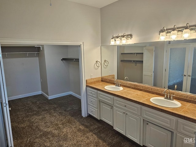 bathroom featuring carpet floors, a sink, and double vanity
