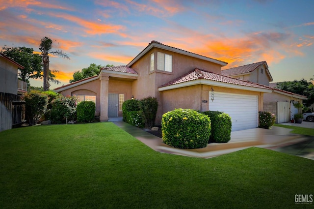 6008 Alderpointe St, Bakersfield, CA 93313 - mediterranean / spanish house featuring an attached garage, a front lawn, concrete driveway, and stucco siding