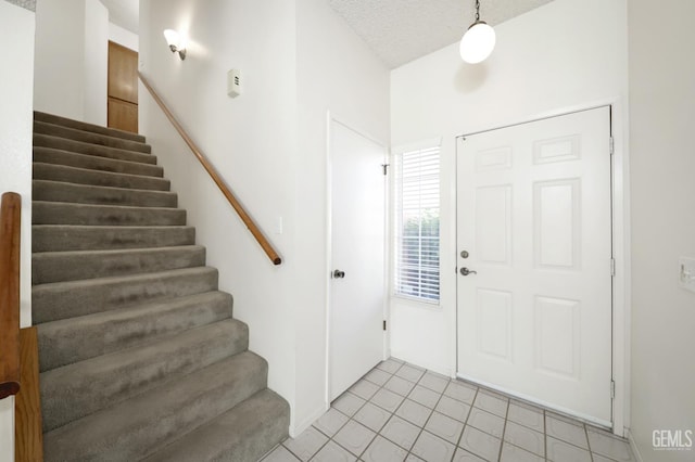 6008 Alderpointe St, Bakersfield, CA 93313 - foyer featuring stairway, light tile patterned floors, and a textured ceiling