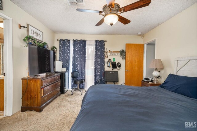 bedroom featuring a ceiling fan, a textured ceiling, visible vents, and carpet