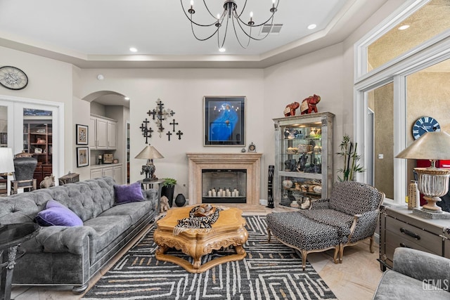 1904 Cricket Park Ct, Bakersfield, CA 93311 - living area featuring arched walkways, a chandelier, a fireplace, recessed lighting, and a tray ceiling