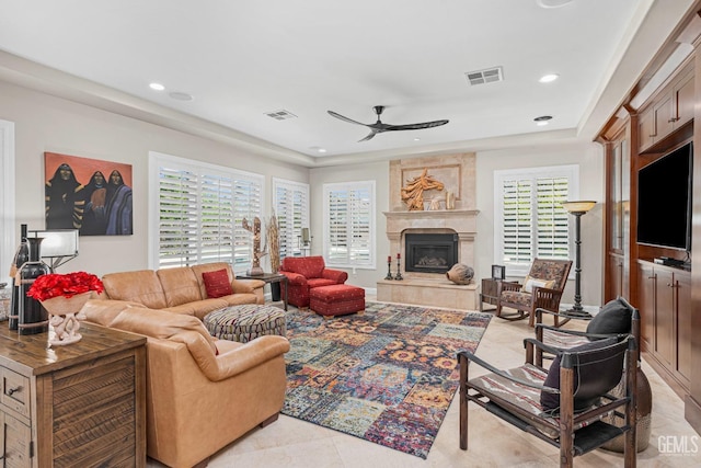 1904 Cricket Park Ct, Bakersfield, CA 93311 - living room with a ceiling fan, a tray ceiling, a premium fireplace, recessed lighting, and light tile patterned flooring