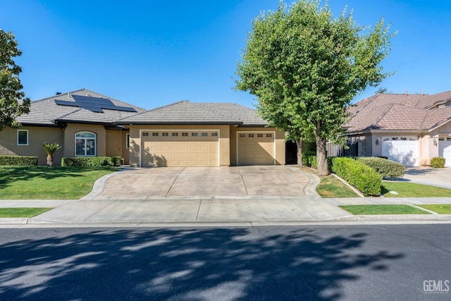 1904 Cricket Park Ct, Bakersfield, CA 93311 - view of front of property featuring an attached garage, stucco siding, solar panels, concrete driveway, and a front lawn
