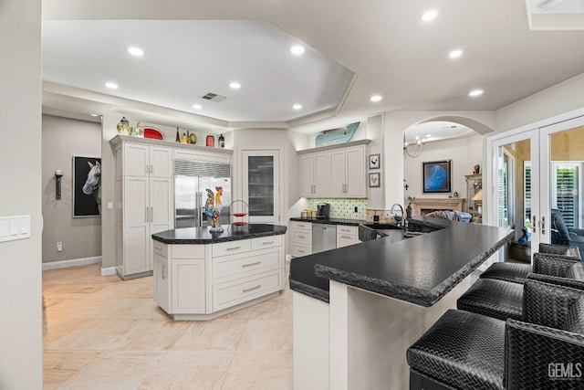 1904 Cricket Park Ct, Bakersfield, CA 93311 - kitchen featuring appliances with stainless steel finishes, dark countertops, arched walkways, a breakfast bar area, and recessed lighting