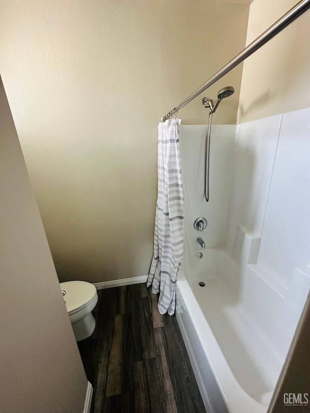 full bathroom featuring toilet, shower / tub combo, wood finished floors, and baseboards