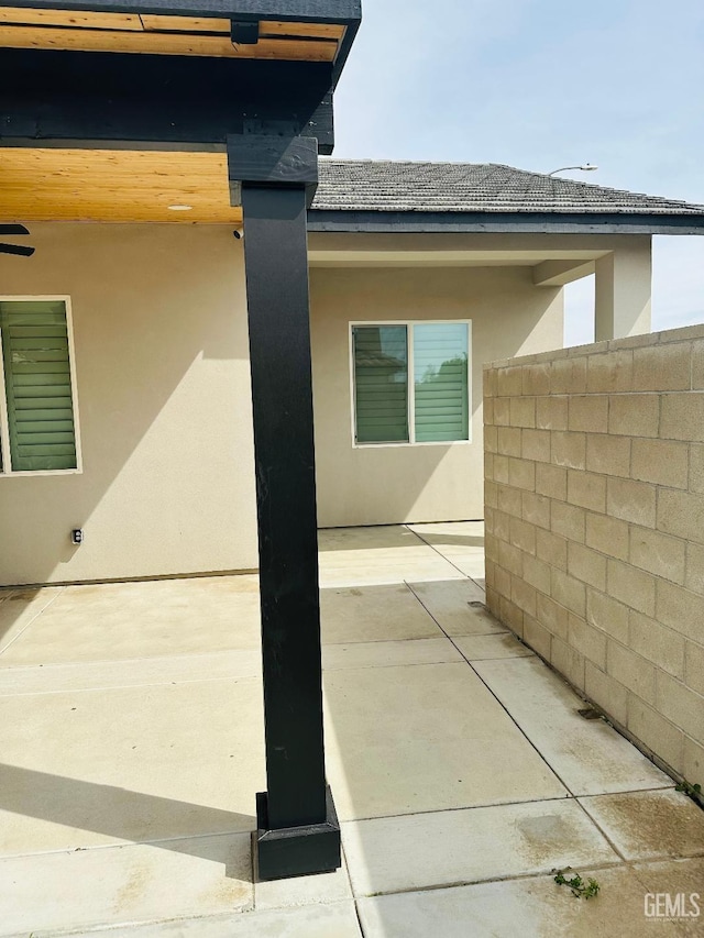 exterior space with fence, stucco siding, and a patio area
