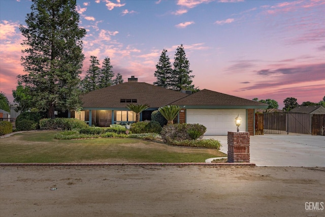 view of front of property featuring concrete driveway, an attached garage, and a gate