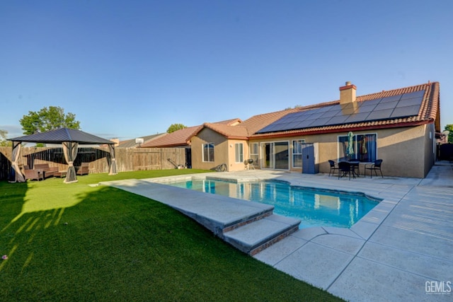 4716 Ambrister Dr, Bakersfield, CA 93313 - rear view of property with a gazebo, a yard, stucco siding, a fenced backyard, and roof mounted solar panels