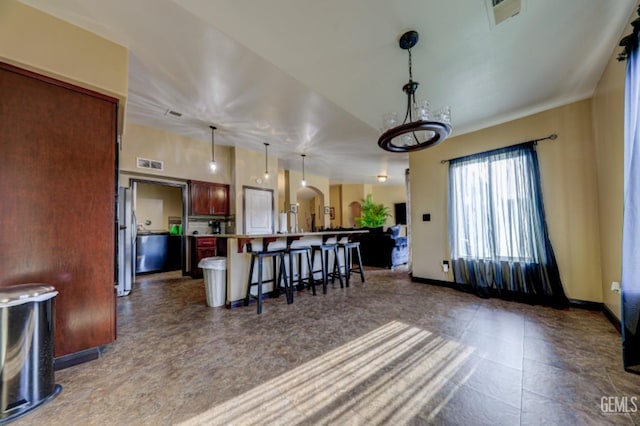 4716 Ambrister Dr, Bakersfield, CA 93313 - interior space with pendant lighting, a breakfast bar area, visible vents, open floor plan, and a kitchen island