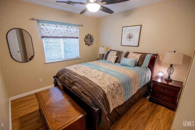 bedroom featuring a ceiling fan, baseboards, and wood finished floors