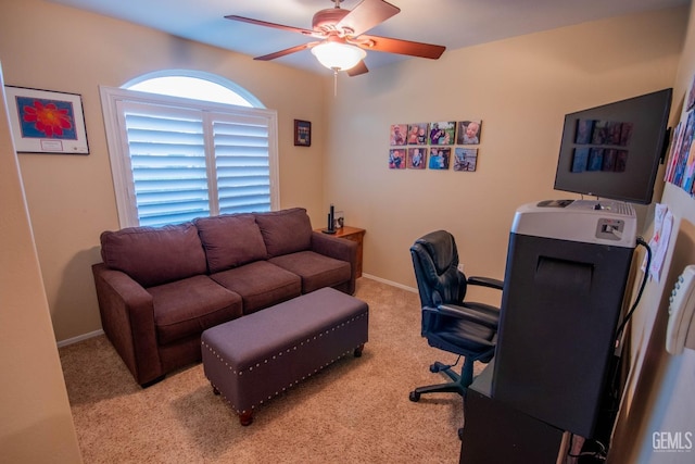 carpeted office featuring baseboards and ceiling fan