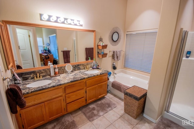 full bath with a sink, a garden tub, double vanity, and tile patterned floors