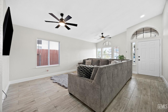 living room with ceiling fan, lofted ceiling, and light hardwood / wood-style floors