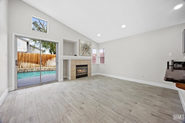 unfurnished living room featuring a fireplace, high vaulted ceiling, and light wood-type flooring