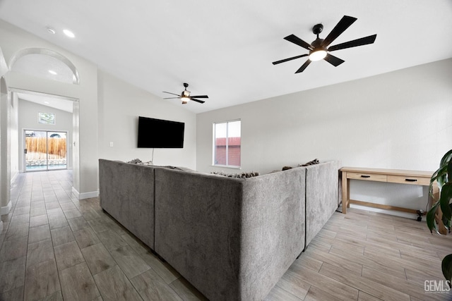 unfurnished living room featuring vaulted ceiling and ceiling fan