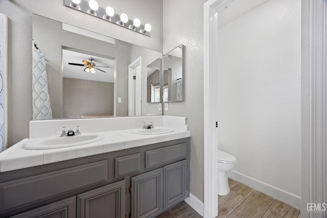 bathroom featuring vanity, ceiling fan, wood-type flooring, and toilet