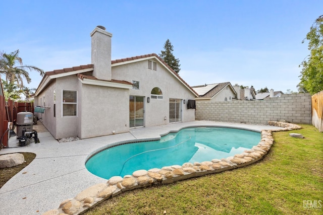 view of pool with a patio area and a lawn