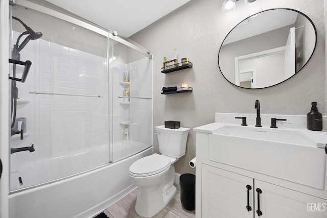 full bathroom featuring toilet, vanity, bath / shower combo with glass door, and hardwood / wood-style flooring