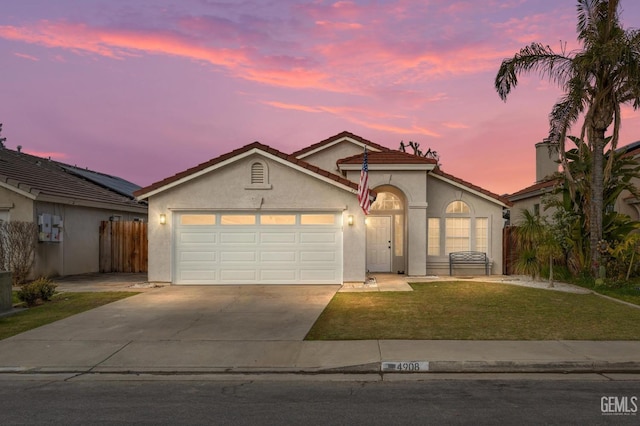 view of front of property featuring a garage and a lawn