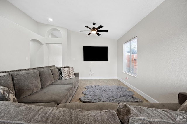 living room with ceiling fan, light hardwood / wood-style floors, and vaulted ceiling