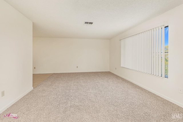 unfurnished room featuring a textured ceiling and carpet flooring