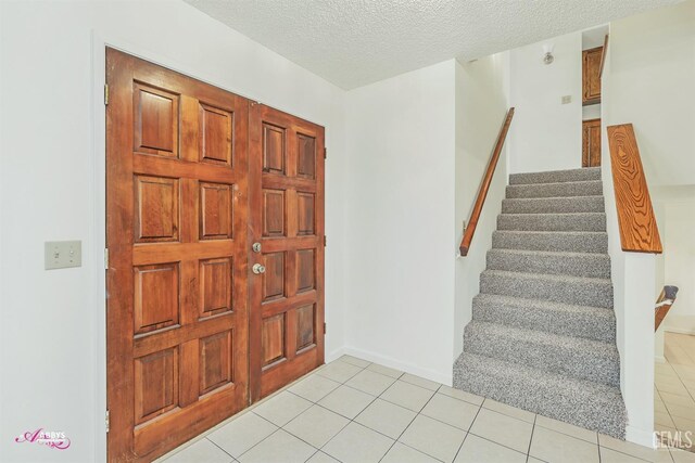 tiled entrance foyer featuring a textured ceiling