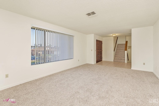 carpeted spare room with a textured ceiling