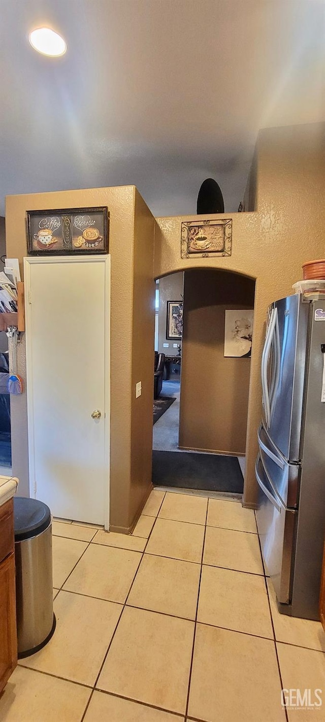 kitchen with stainless steel fridge and light tile patterned flooring