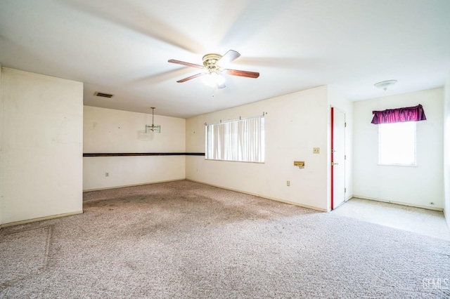 carpeted spare room with a wealth of natural light and ceiling fan