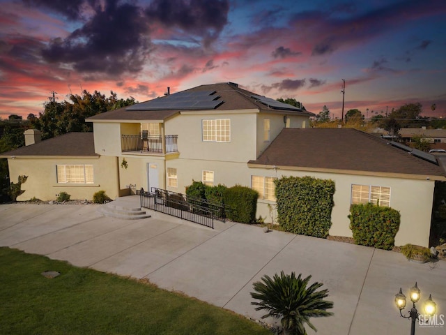 view of front of home featuring solar panels and a balcony