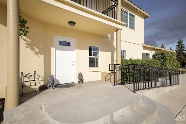 property entrance with a balcony and a patio