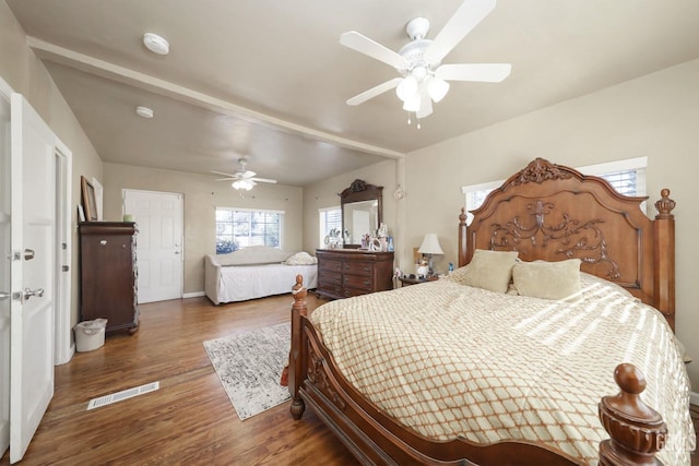 bedroom with ceiling fan, beamed ceiling, and dark hardwood / wood-style floors