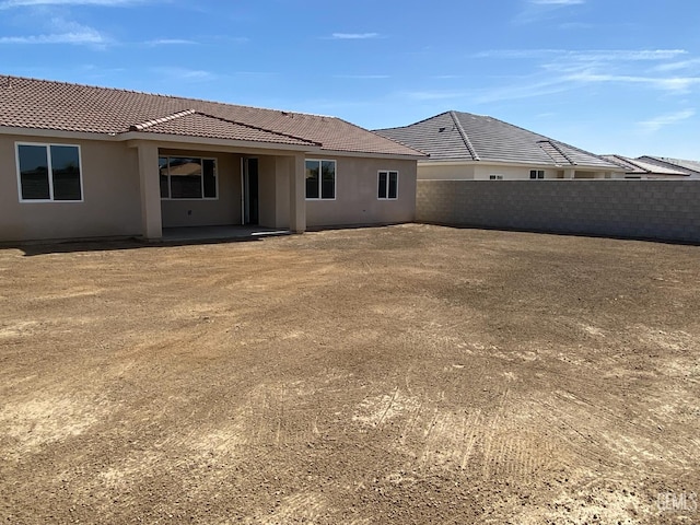 12706 Kinnick Ct, Bakersfield, CA 93311 - back of property with a tiled roof, stucco siding, and a patio area