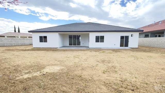 back of property featuring fence private yard, a patio area, and stucco siding