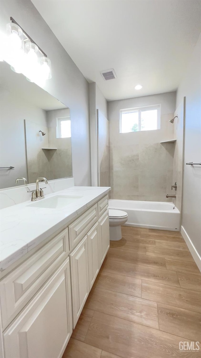 full bathroom featuring toilet, visible vents, plenty of natural light, and bathing tub / shower combination