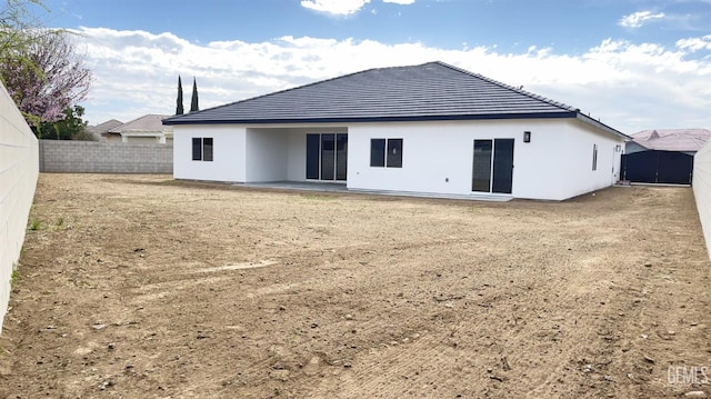 back of property with a fenced backyard and stucco siding