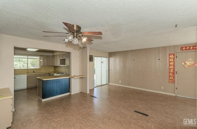 kitchen with a ceiling fan, a textured ceiling, visible vents, white dishwasher, and a peninsula