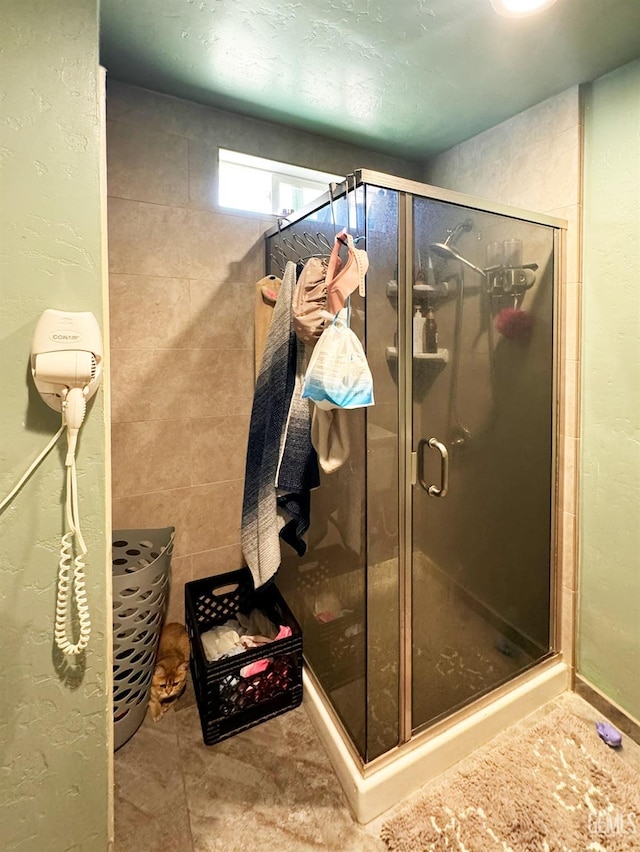 bathroom featuring a shower with door and tile patterned flooring