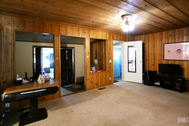 living room featuring light carpet, wood ceiling, and wood walls