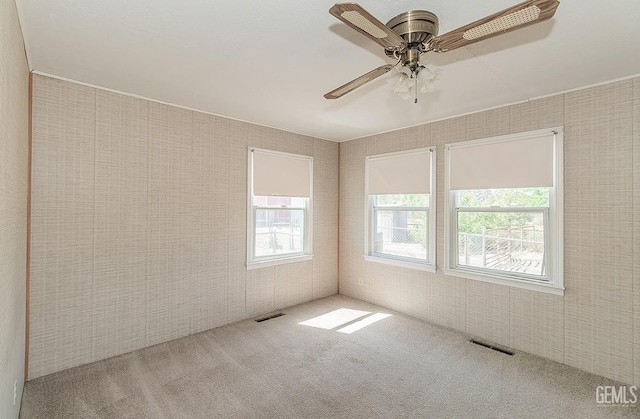 unfurnished room featuring visible vents, carpet flooring, and ceiling fan