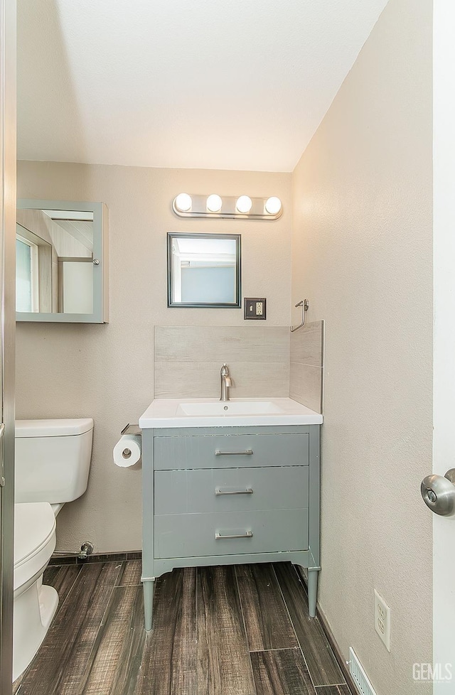 bathroom featuring vanity, toilet, and wood finished floors