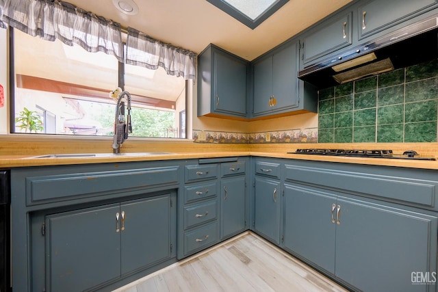 4508 Glengary Pl, Bakersfield, CA 93313 - kitchen featuring a sink, range hood, gas cooktop, light countertops, and light wood-style floors