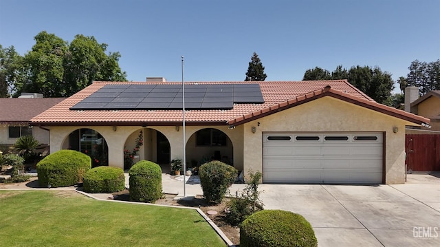 4508 Glengary Pl, Bakersfield, CA 93313 - mediterranean / spanish-style home with concrete driveway, stucco siding, an attached garage, and roof mounted solar panels